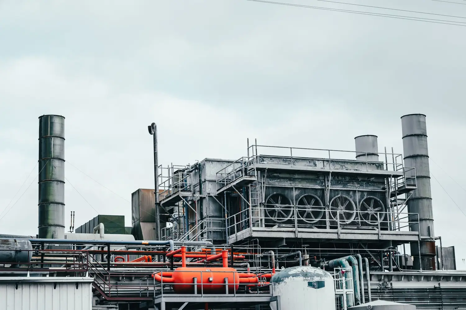 Exterior of an industrial process plant with stacks, ducting and steel walkways