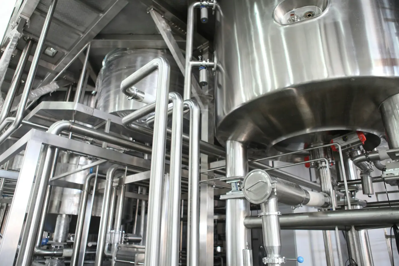 Stainless-steel process tanks and interconnected piping in an industrial plant