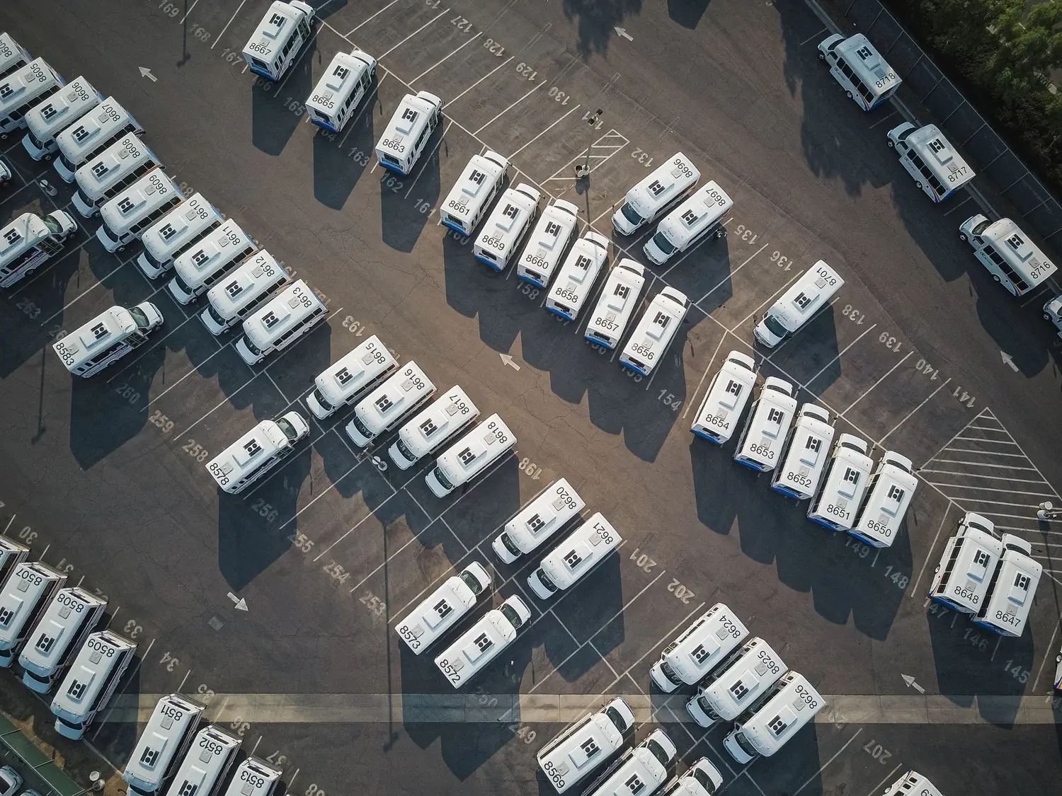 Aerial view of a commercial vehicle fleet parked in numbered bays at a depot