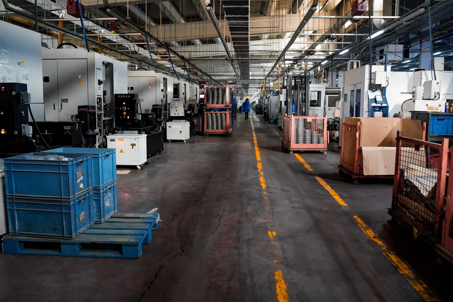 Long aisle of CNC machining centres running down a plant production floor